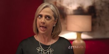 Movie still from “Christmas Full of Grace” (2022), directed by Pedro Antônio Paes – A woman in a black shirt is looking angry at the camera; Close Up shot, Over the shoulder angle