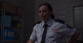 Movie still from “Christmas Ransom” (2022), directed by Adele Vuko – A woman in a police uniform is looking at the camera; Close Up shot, Over the shoulder angle