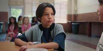 Movie still from “Chupa” (2023), directed by Jonás Cuarón – A boy sitting at a table in front of a window; Close Up shot, Over the shoulder angle