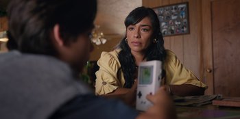 Movie still from “Chupa” (2023), directed by Jonás Cuarón – A woman sitting in front of a man holding a video game controller; Close Up shot, Over the shoulder angle