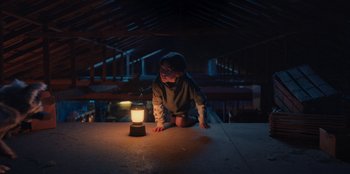 Movie still from “Chupa” (2023), directed by Jonás Cuarón – A young boy is sitting on the floor looking at a lantern; Wide shot, Low angle
