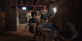 Movie still from “Chupa” (2023), directed by Jonás Cuarón – A group of people and a dog in a barn; Medium shot, Over the shoulder angle