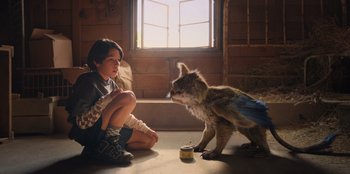 Movie still from “Chupa” (2023), directed by Jonás Cuarón – A young girl sitting on the ground next to a wolf cub; Medium shot, Low angle