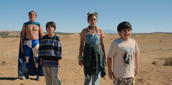 Movie still from “Chupa” (2023), directed by Jonás Cuarón – Three people standing in the sand on a beach; Medium shot, Low angle