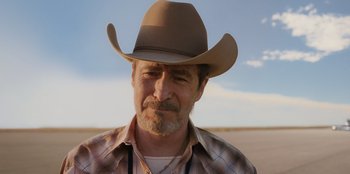 Movie still from “Chupa” (2023), directed by Jonás Cuarón – A man with a cowboy hat and a beard; Close Up shot, Low angle