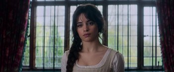 Movie still from “Cinderella” (2021), directed by Kay Cannon – A woman with long black hair wearing a white dress; Close Up shot, Over the shoulder angle