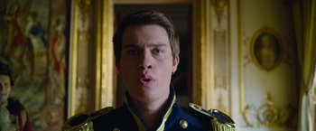 Movie still from “Cinderella” (2021), directed by Kay Cannon – A young man in a military uniform making a funny face; Close Up shot, Low angle