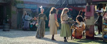 Movie still from “Cinderella” (2021), directed by Kay Cannon – A group of women dressed in period clothing; Wide shot, Over the shoulder angle