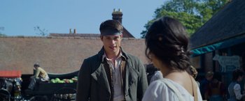 Movie still from “Cinderella” (2021), directed by Kay Cannon – A man and a woman standing next to each other; Medium shot, Over the shoulder angle