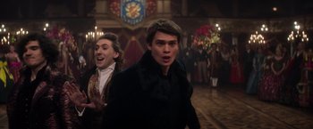 Movie still from “Cinderella” (2021), directed by Kay Cannon – A man in a black jacket and a man in a black jacket; Medium shot, Over the shoulder angle