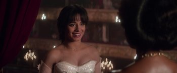 Movie still from “Cinderella” (2021), directed by Kay Cannon – A woman in a white dress smiling for the camera; Close Up shot, Over the shoulder angle