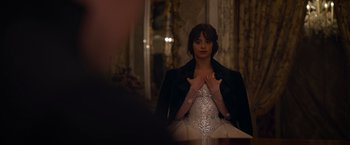 Movie still from “Cinderella” (2021), directed by Kay Cannon – A woman in a white dress and a black jacket; Medium shot, Over the shoulder angle