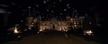 Movie still from “Cinderella” (2021), directed by Kay Cannon – A large building that is lit up at night; Extreme Wide shot, High angle