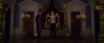 Movie still from “Cinderella” (2021), directed by Kay Cannon – A man and a woman standing in front of a throne; Wide shot, Over the shoulder angle