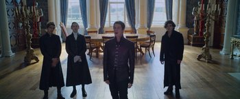 Movie still from “Cinderella” (2021), directed by Kay Cannon – Three people are standing in a room singing; Medium shot, Low angle