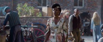 Movie still from “Cinderella” (2021), directed by Kay Cannon – A woman in a dress and a bow in her hair; Medium shot, Over the shoulder angle