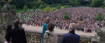 Movie still from “Cinderella” (2021), directed by Kay Cannon – A crowd of people gathered in a park to watch; Extreme Wide shot, High angle