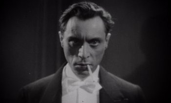 Movie still from “Cinema Paradiso” (1988), directed by Giuseppe Tornatore – An old black and white photo of a man smoking a cigarette; Close Up shot, Low angle