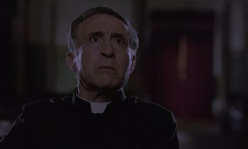 Movie still from “Cinema Paradiso” (1988), directed by Giuseppe Tornatore – A man wearing a priest's outfit looking up at the sky; Close Up shot, Low angle
