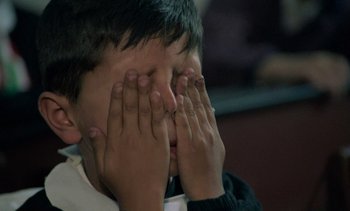 Movie still from “Cinema Paradiso” (1988), directed by Giuseppe Tornatore – A boy covering his eyes with his hands; Close Up shot, Over the shoulder angle