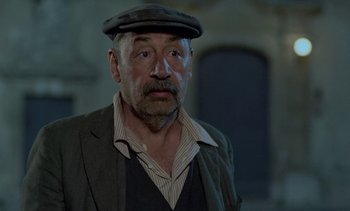 Movie still from “Cinema Paradiso” (1988), directed by Giuseppe Tornatore – An older man wearing a hat and a jacket; Close Up shot, Low angle