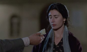 Movie still from “Cinema Paradiso” (1988), directed by Giuseppe Tornatore – A woman is being given a piece of paper by a man; Close Up shot, Over the shoulder angle