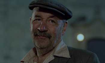Movie still from “Cinema Paradiso” (1988), directed by Giuseppe Tornatore – An older man wearing a hat and a jacket; Close Up shot, Low angle