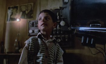 Movie still from “Cinema Paradiso” (1988), directed by Giuseppe Tornatore – A young boy standing in front of a television; Medium shot, Low angle