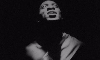 Movie still from “Cinema Paradiso” (1988), directed by Giuseppe Tornatore – A black - and - white photo of a man in a tie; Extreme Close Up shot, Low angle