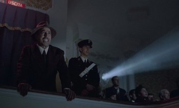 Movie still from “Cinema Paradiso” (1988), directed by Giuseppe Tornatore – A group of men standing next to each other in a room; Medium shot, Low angle