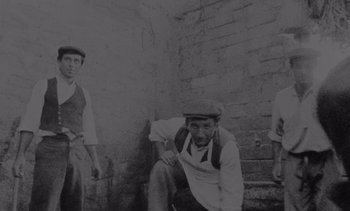 Movie still from “Cinema Paradiso” (1988), directed by Giuseppe Tornatore – A group of men standing next to a brick wall; Wide shot, Low angle