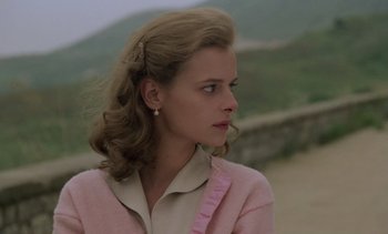 Movie still from “Cinema Paradiso” (1988), directed by Giuseppe Tornatore – A young woman with long blonde hair wearing a pink jacket; Close Up shot, Low angle