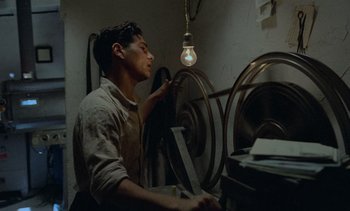 Movie still from “Cinema Paradiso” (1988), directed by Giuseppe Tornatore – A man working in an industrial machine shop; Medium shot, Low angle