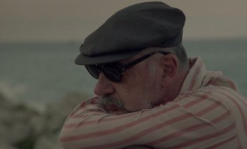 Movie still from “Cinema Paradiso” (1988), directed by Giuseppe Tornatore – An older man wearing a hat and sunglasses; Close Up shot, Low angle