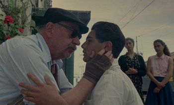 Movie still from “Cinema Paradiso” (1988), directed by Giuseppe Tornatore – A man and a boy are touching each other's face; Close Up shot, Over the shoulder angle