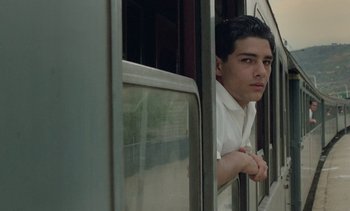 Movie still from “Cinema Paradiso” (1988), directed by Giuseppe Tornatore – A young man looking out of a train window; Close Up shot, Low angle