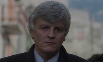 Movie still from “Cinema Paradiso” (1988), directed by Giuseppe Tornatore – A person wearing a suit and tie; Close Up shot, Low angle