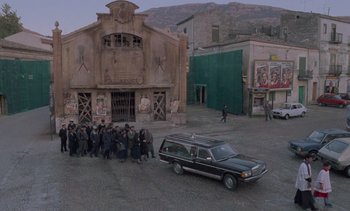 Movie still from “Cinema Paradiso” (1988), directed by Giuseppe Tornatore – A group of people standing next to a car; Extreme Wide shot, High angle