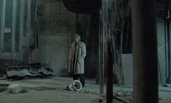 Movie still from “Cinema Paradiso” (1988), directed by Giuseppe Tornatore – An old man standing in an abandoned building; Wide shot, High angle