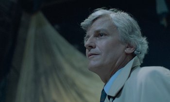 Movie still from “Cinema Paradiso” (1988), directed by Giuseppe Tornatore – An older man wearing a jacket and tie; Close Up shot, Low angle