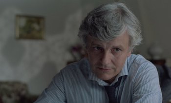Movie still from “Cinema Paradiso” (1988), directed by Giuseppe Tornatore – An older man wearing a striped shirt and a tie; Close Up shot, Over the shoulder angle