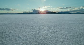 Movie still from “The Tree of Life” (2011), directed by Terrence Malick – The sun is setting over a large expanse of land; Extreme Wide shot, High angle