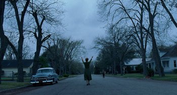 Movie still from “The Tree of Life” (2011), directed by Terrence Malick – A woman in a green dress standing in the middle of a street; Extreme Wide shot, Low angle