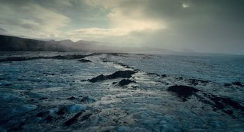 Movie still from “The Tree of Life” (2011), directed by Terrence Malick – A body of water that has some rocks in the water; Extreme Wide shot, High angle