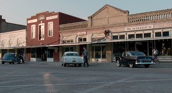 Movie still from “The Tree of Life” (2011), directed by Terrence Malick – A man walking across the street in front of an old car; Extreme Wide shot, Over the shoulder angle