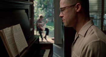 Movie still from “The Tree of Life” (2011), directed by Terrence Malick – A man sitting in front of an open piano; Close Up shot, Over the shoulder angle