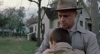 Movie still from “The Tree of Life” (2011), directed by Terrence Malick – A man holding a young boy in his arms outside; Close Up shot, Over the shoulder angle