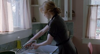 Movie still from “The Tree of Life” (2011), directed by Terrence Malick – A woman in an apron washing dishes in a sink; Medium shot, Over the shoulder angle