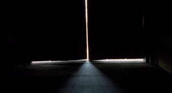 Movie still from “The Tree of Life” (2011), directed by Terrence Malick – A long pole is lit up in the dark; Extreme Wide shot, Low angle