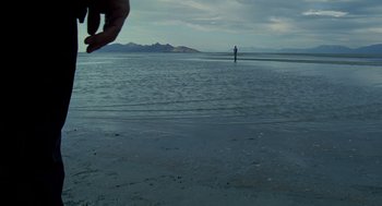 Movie still from “The Tree of Life” (2011), directed by Terrence Malick – A man standing on a beach in the water; Extreme Wide shot, Over the shoulder angle
